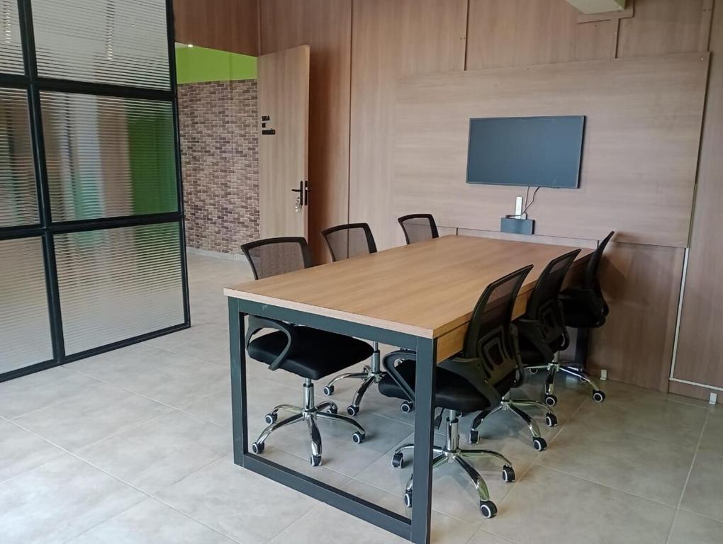 a conference room with a wooden table and chairs at Studio Sereno in Barbacena