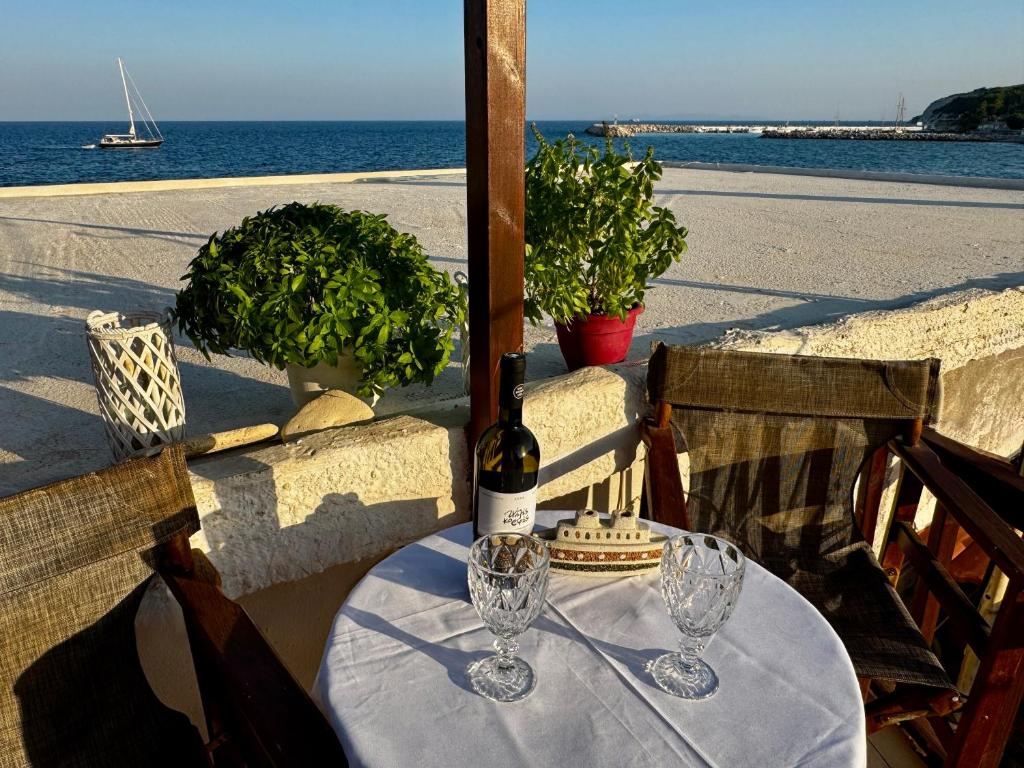 ein Tisch mit zwei Gläsern und einer Flasche Wein in der Unterkunft Ireon Seaside Breeze studio in Ireo