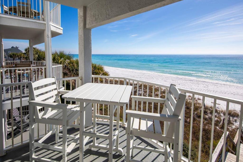 un tavolo e sedie su un balcone con vista sulla spiaggia di Whispering Sands #202 a Coffeyville