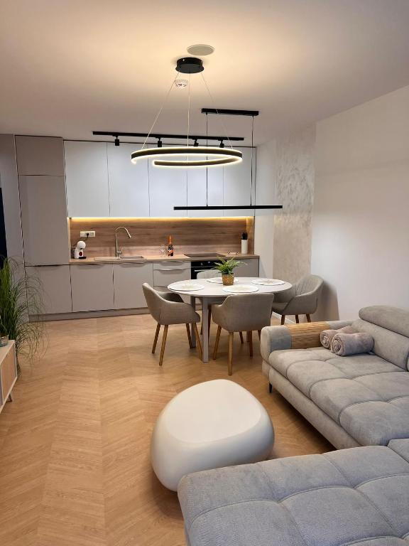 a living room with a table and a kitchen at Spa Apartman Bardejovské kúpele s dvoma izbami in Bardejovské Kúpele