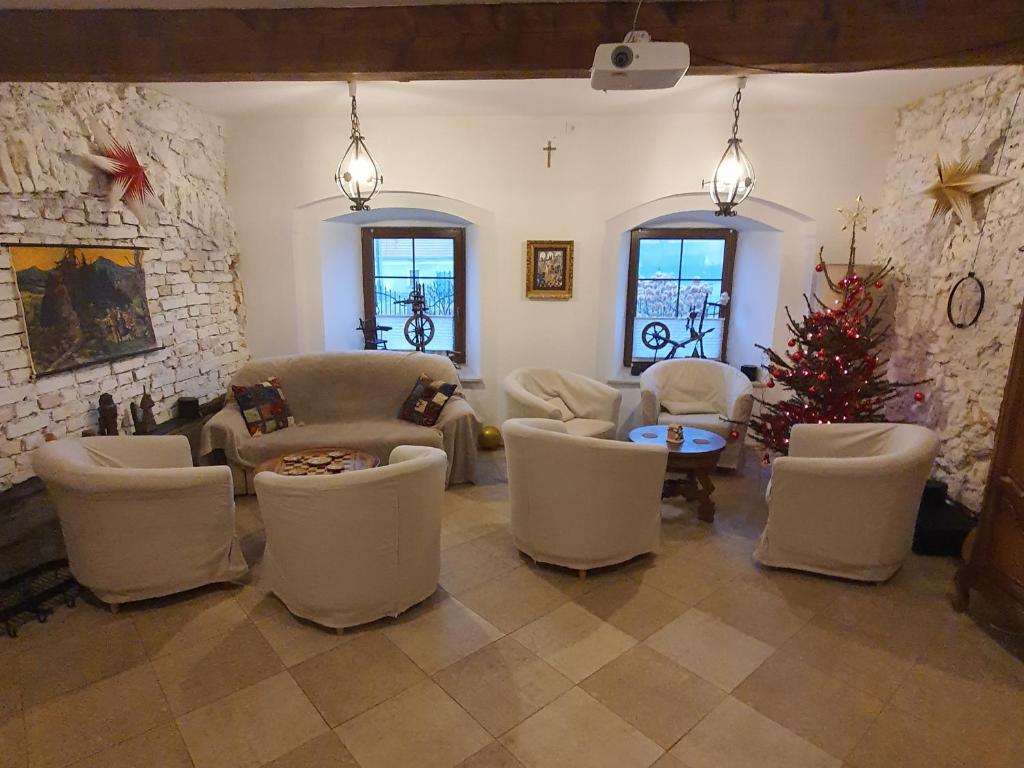 un soggiorno con sedie bianche e un albero di Natale di Dworek Marmis - idealny dla rodzin a Mirsk