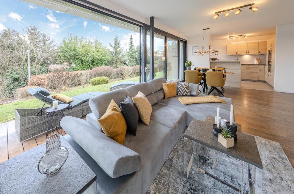 a living room with a gray couch and a large window at Konny in Gaienhofen