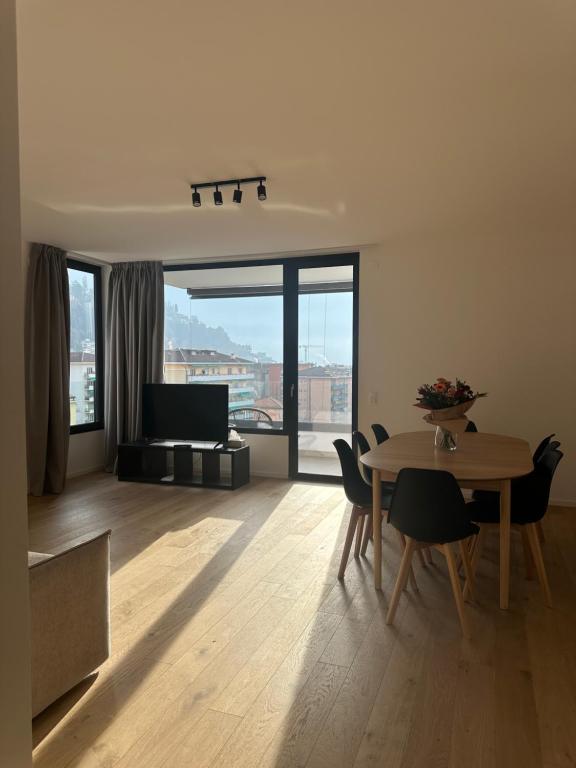 a living room with a table and chairs and a couch at Live Lugano - Via Muggina in Viganello