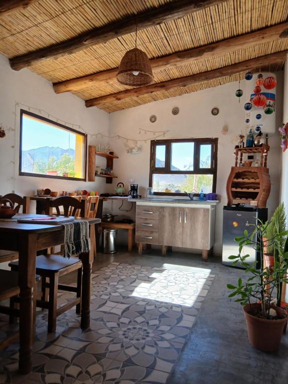 une cuisine avec une table, des chaises et un évier dans l'établissement Cabaña Paraíso Cachi, à Cachí