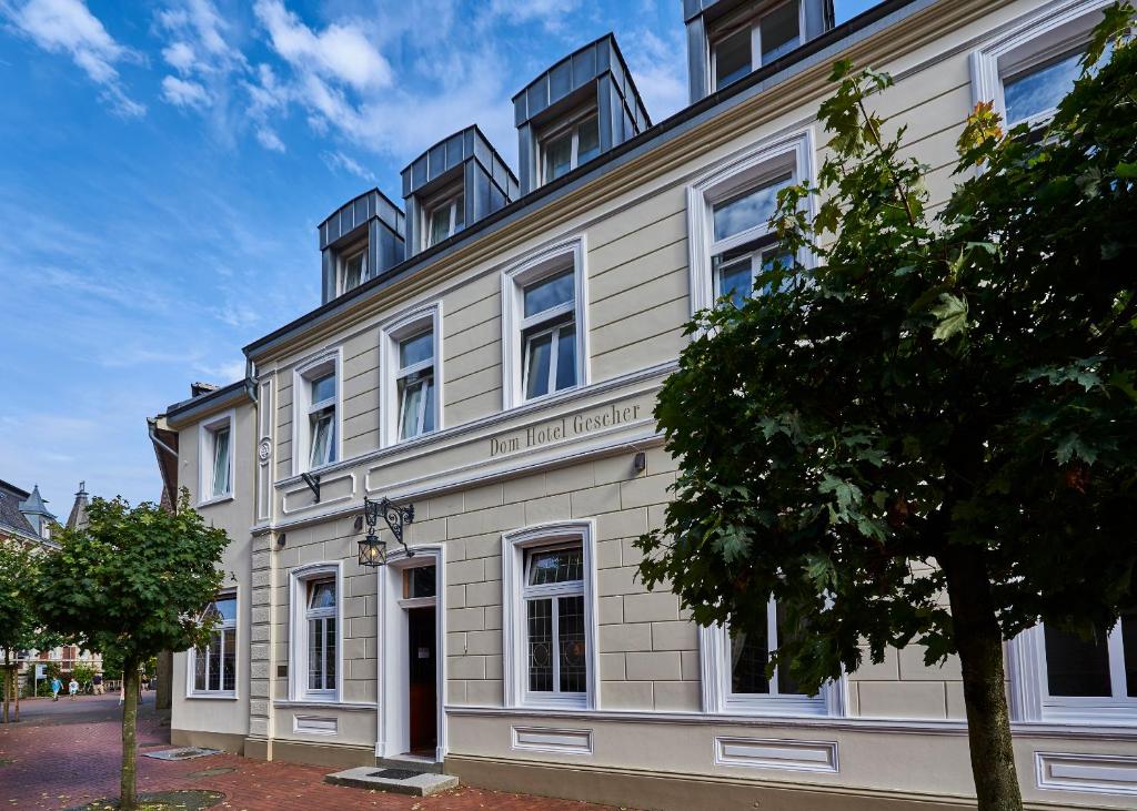 ein großes weißes Gebäude mit Fenstern auf einer Straße in der Unterkunft Dom Hotel in Gescher