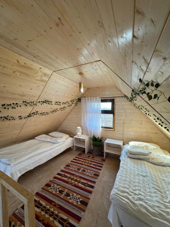 een kamer met twee bedden in een houten hut bij Coral houses in Tossor