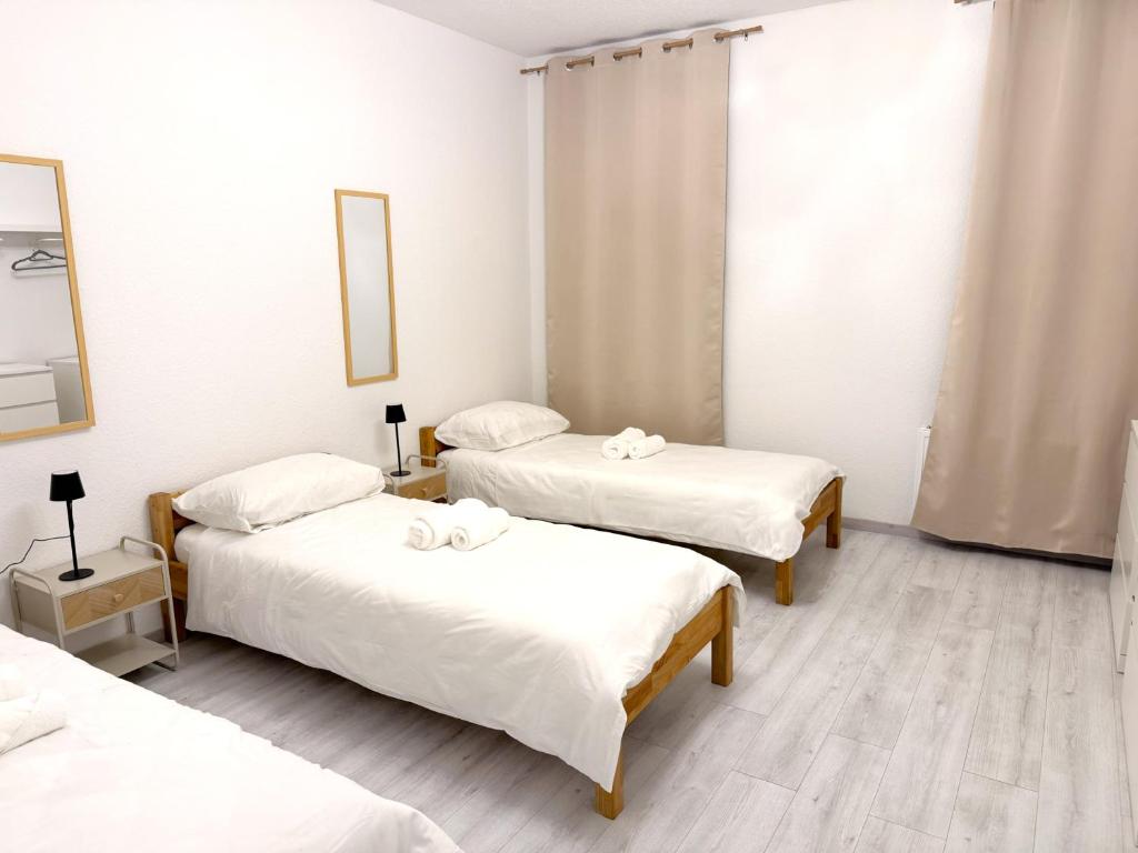 een kamer met 3 bedden met witte lakens bij Kölner Street Loft ,Neu Renoviert für bis zu 5 Personen mit Küche und Bad in Düsseldorf