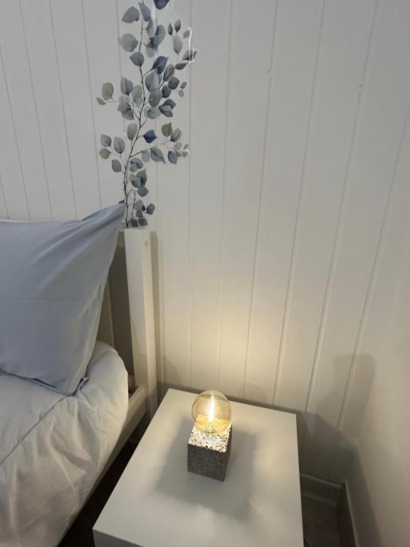 a small table with a candle on it next to a bed at Home Sweet Home Forli in Forlì