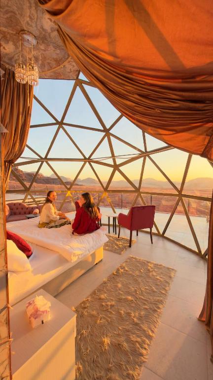 a group of people sitting on beds in a tent at Desert Bedouin Adventure in Wadi Rum