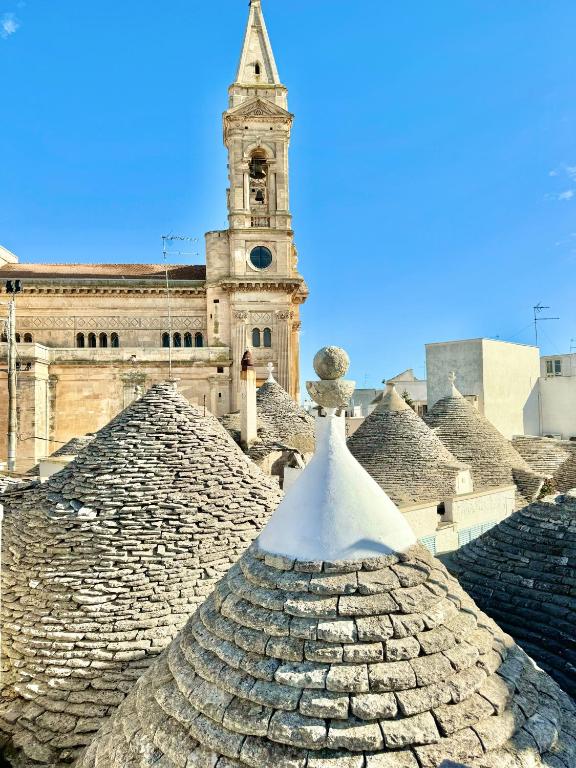 a building with a clock tower in front of it at Trulli Phoenix Alberobello in Alberobello