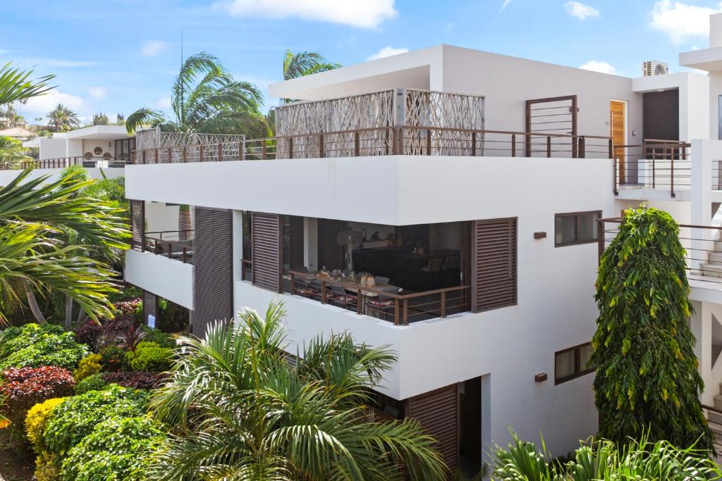 ein Bild eines weißen Hauses mit Bäumen in der Unterkunft The Grand in Jan Thiel