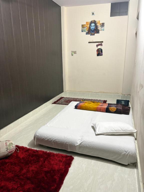 a white bed in a room with a red rug at Pankali niwas in Varanasi