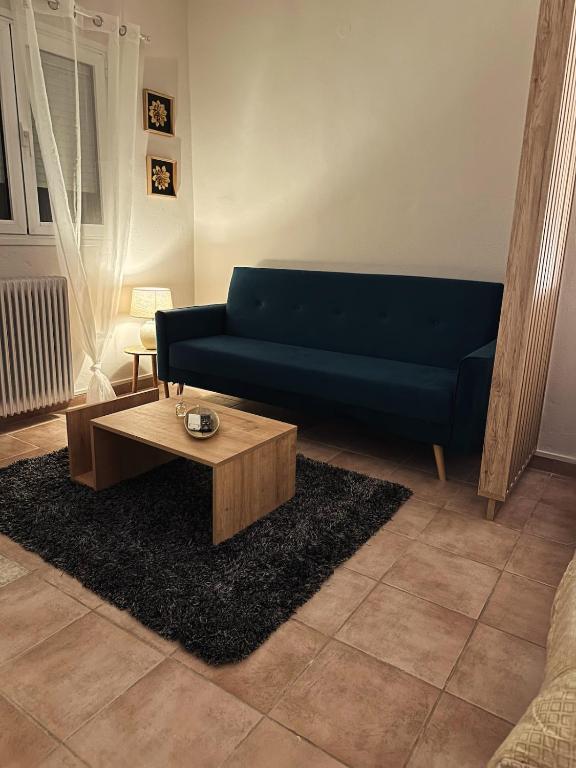 a living room with a blue couch and a coffee table at Little Florina Nest in Florina
