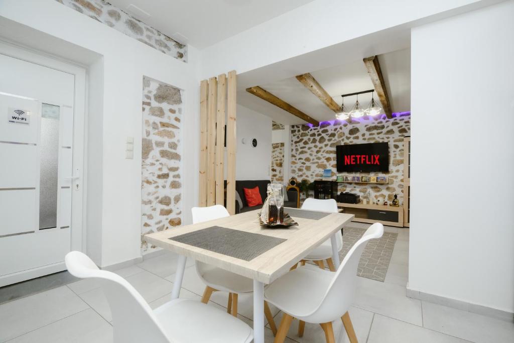 a white dining room with a white table and white chairs at luxury house in Ierapetra