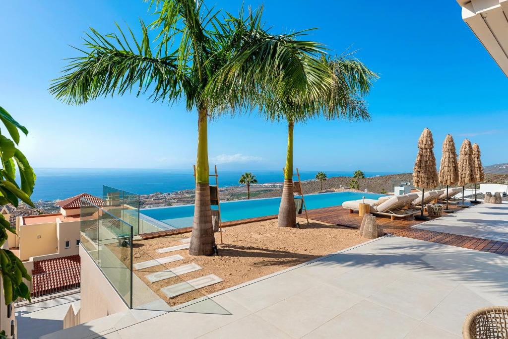een villa met zwembad en palmbomen bij Villa Kailani in Adeje