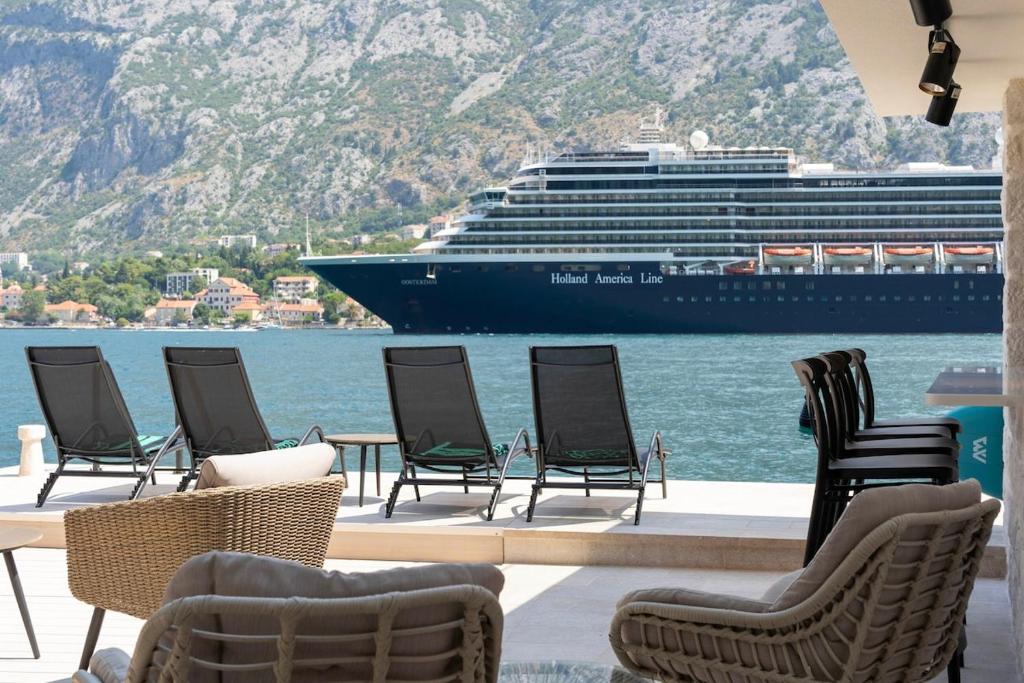 a group of chairs and a cruise ship in the water at Seafront Kotor Bay View Villa NW in Muo