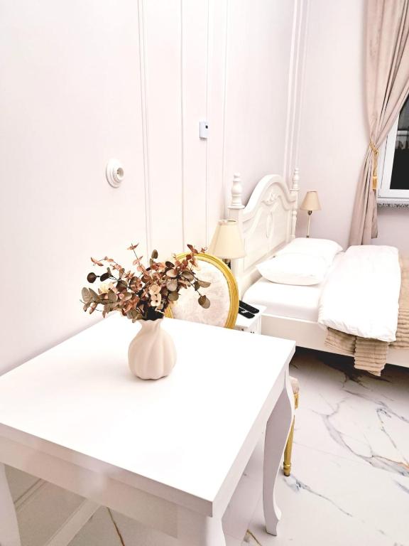 a white room with a table and a bed at Poznaj Mickiewicza 2 in Racibórz