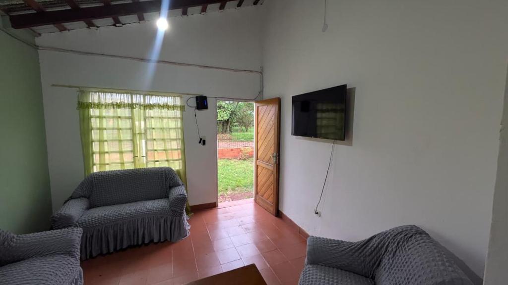 een woonkamer met twee stoelen en een televisie bij Diana hotel 2 in Encarnación