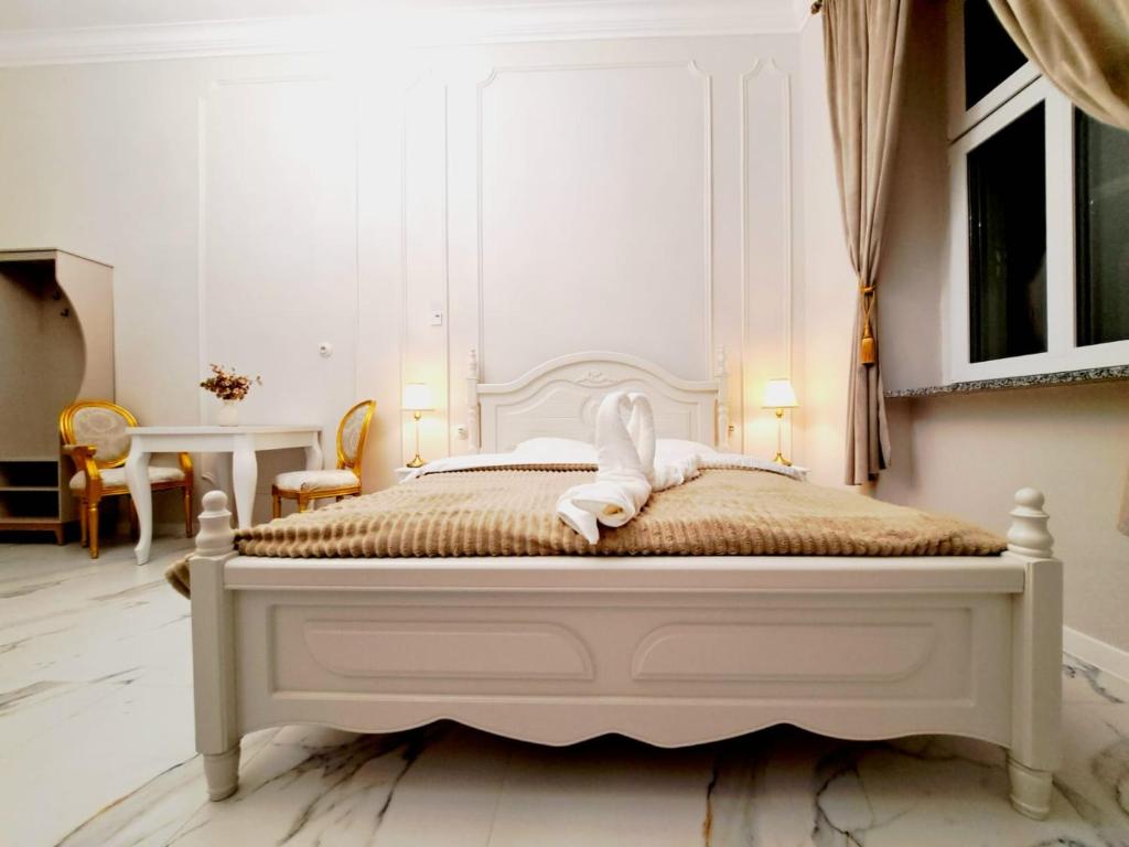 - une chambre dotée d'un lit blanc avec un animal rembourré dans l'établissement Poznaj Mickiewicza 2, à Racibórz