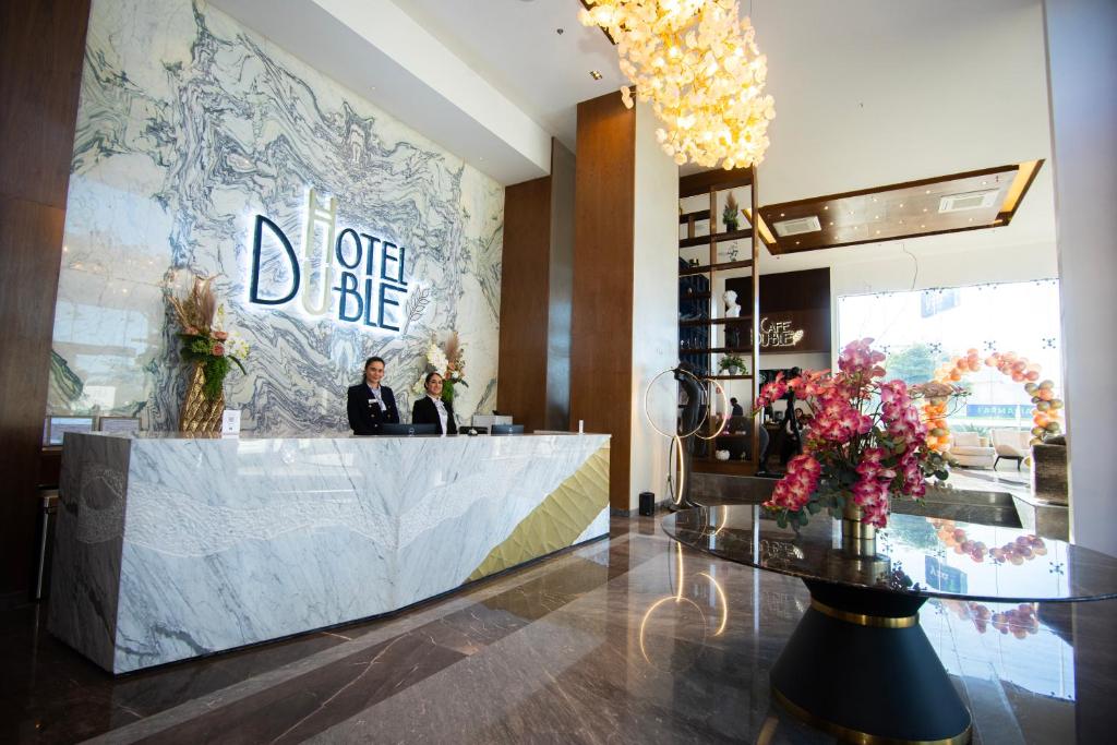 a woman standing behind a counter in a lobby at Hotel Dublé in Navojoa