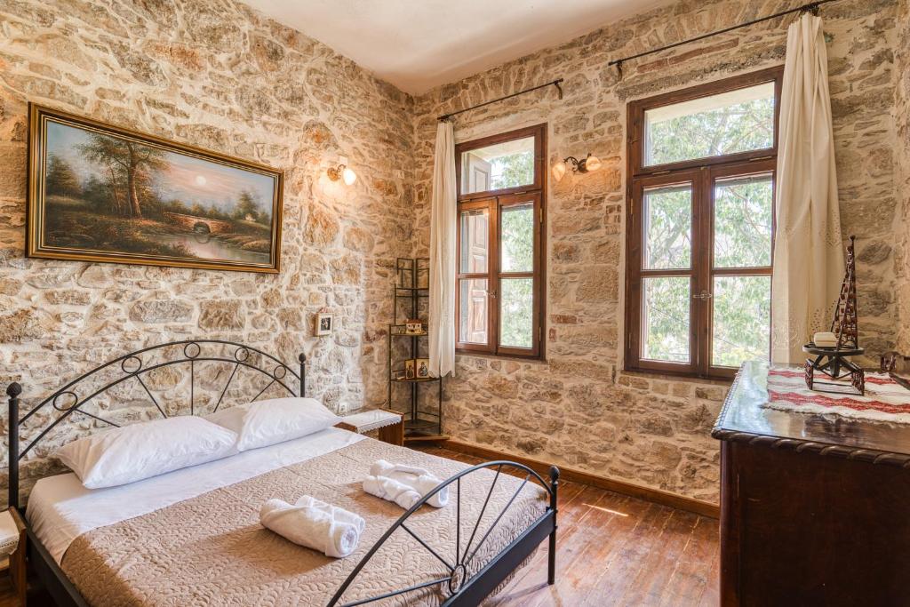 een slaapkamer met een bed in een kamer met stenen muren bij Medieval Villa Philoxenia in Kalamoti