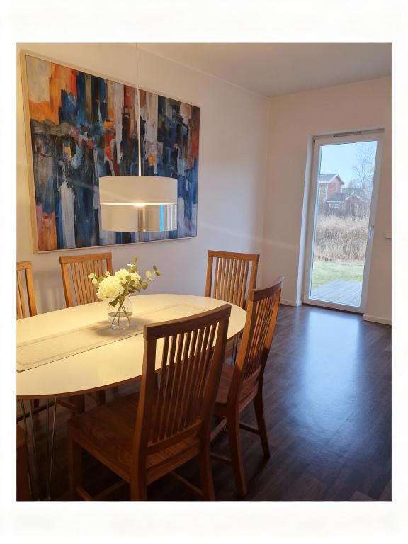 a dining room table with chairs and a vase of flowers at Arcticstay 25A in Pajala