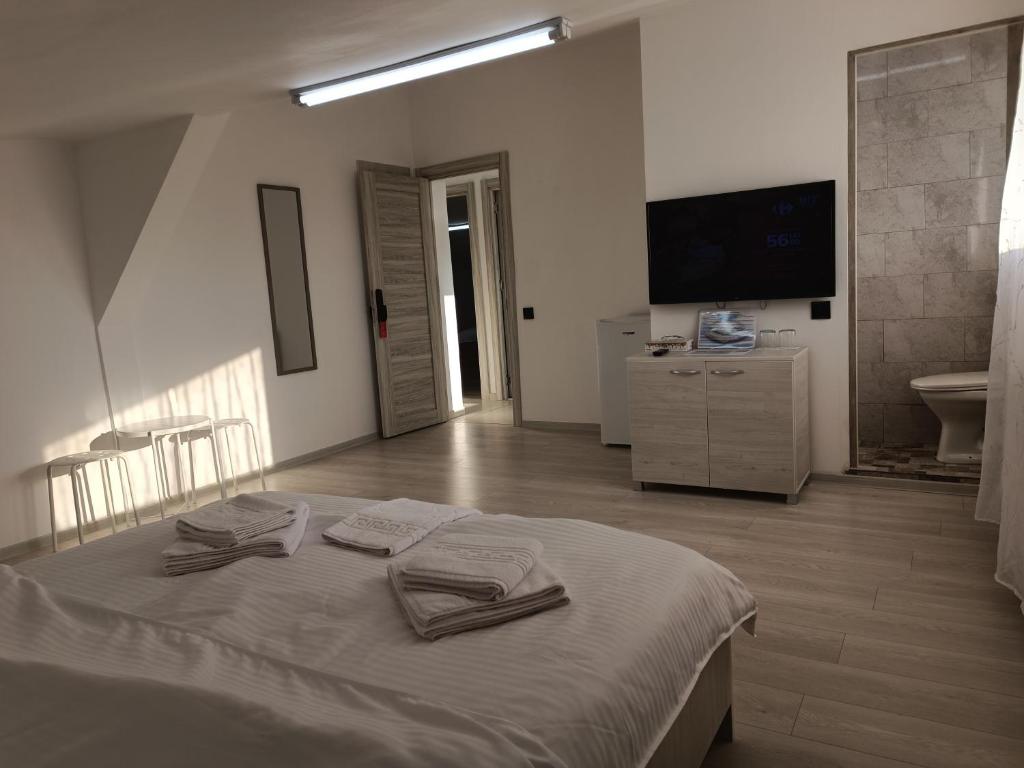 een slaapkamer met een bed met twee handdoeken erop bij Max Night Dreams in Boekarest
