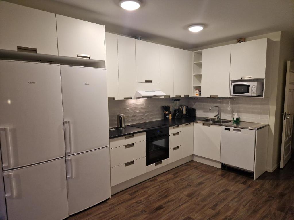 帕亚拉Arcticstay 23A的铺有木地板的厨房配有白色家电