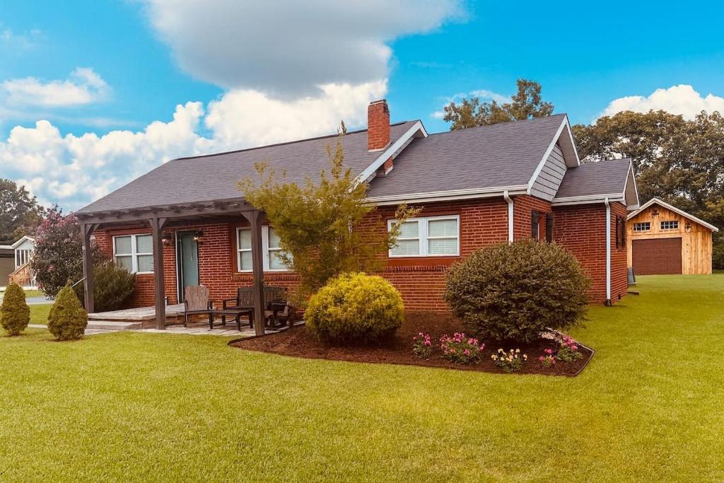 una casa in mattoni rossi con un prato di Little Pigeon Millhouse a Pigeon Forge