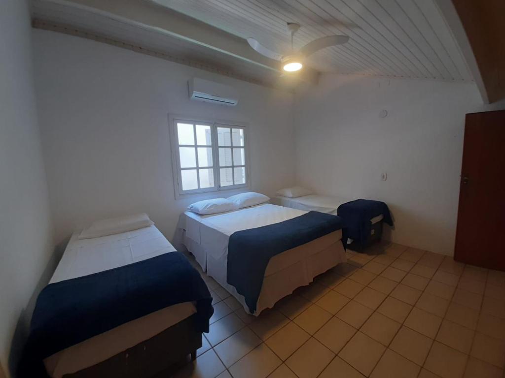 um quarto com duas camas e uma janela em Pousada Pantai Maresias em Maresias