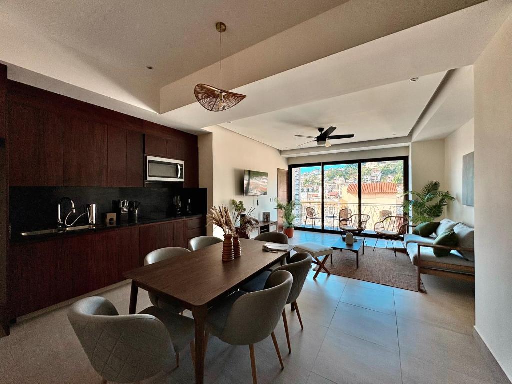 a dining room and living room with a table and chairs at OVATA 401- Zona Romántica in Puerto Vallarta