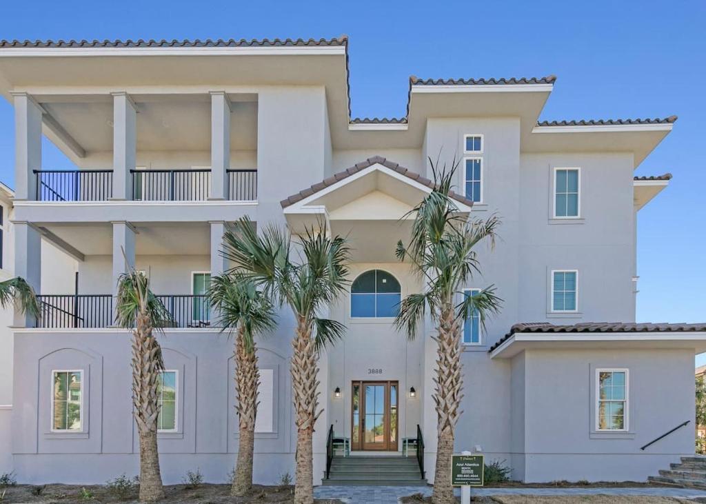een groot wit huis met palmbomen ervoor bij Azul Atlantica in Destin