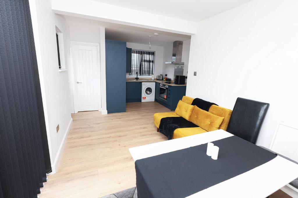 een woonkamer met een tafel en een gele bank bij Modern 3 bedroom home refurbished with parking in Wednesbury