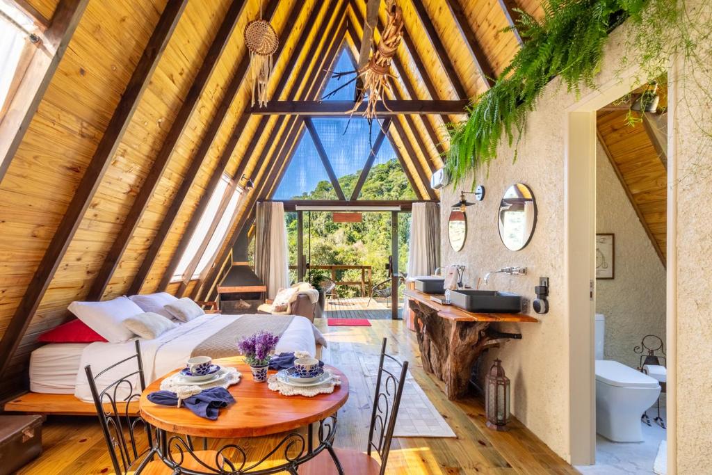 una camera con un letto e un tavolo con sedie di Chale Alcantara Jacuzzi, Lareira e Deck com Vista a São Pedro de Alcântara