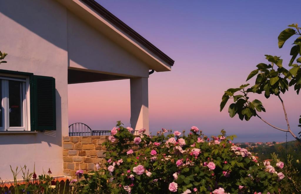 una casa con un cespuglio di fiori accanto a un edificio di Casale Dionisia, Santa Maria di Castellabate, Appartamento Iris a Castellabate