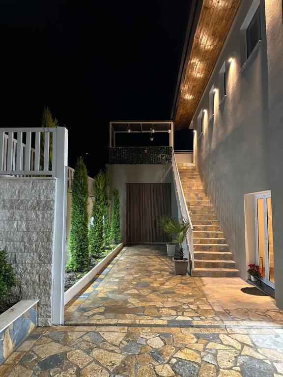 een trap die 's nachts naar een huis leidt bij Kremelo Hotel in Berat