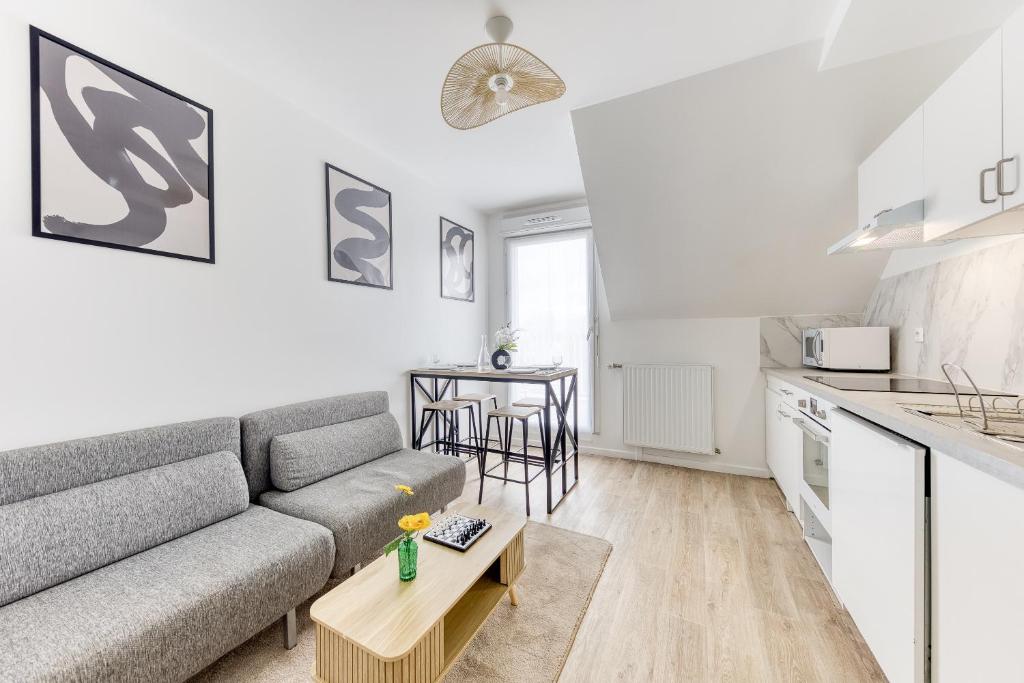 a living room with a couch and a table at Cinéhouse, Proche Paris 5 min, 2 chambre in Bobigny