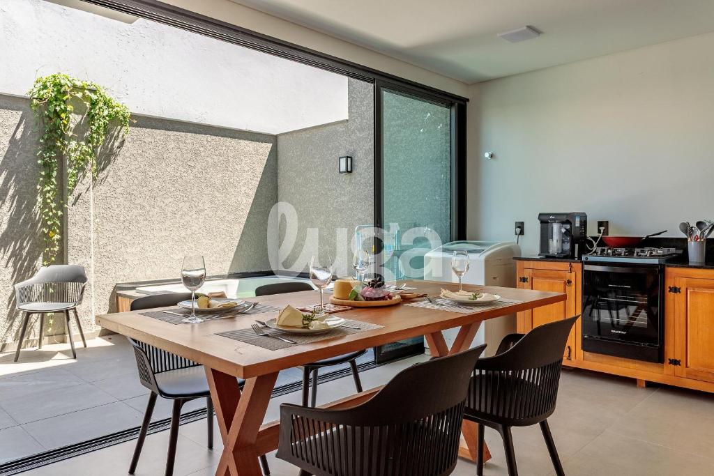 a dining room with a table and chairs and a kitchen at LUGA Relax House with Jacuzzi in Palhoça