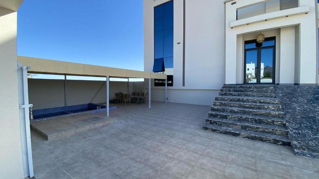 un edificio con una scala e un edificio con una panchina di Mountain Breeze Stay a Sayq