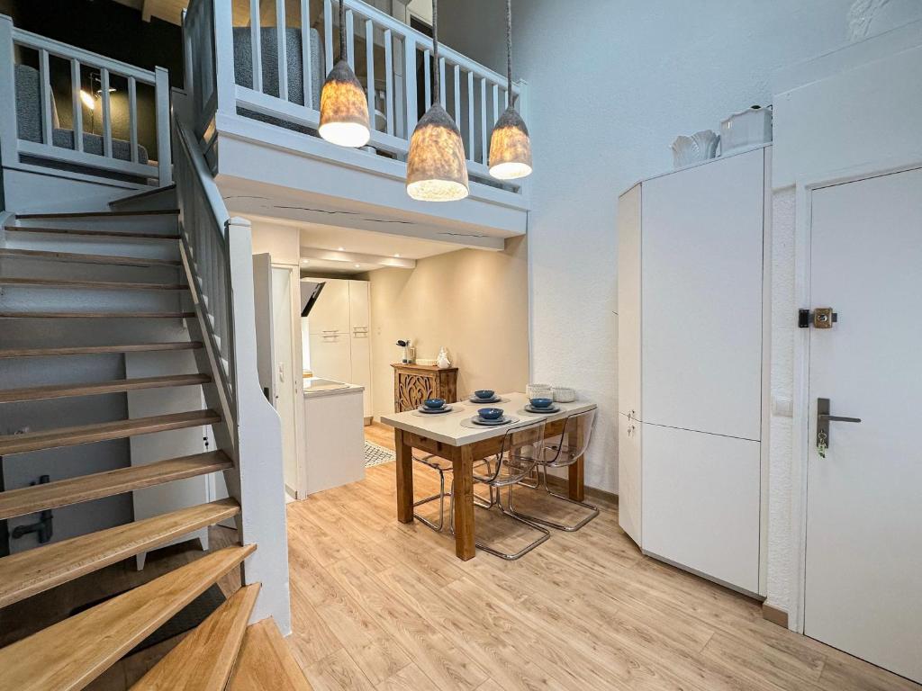 a hallway with a table and a staircase in a building at Triplex Léonie - Standing and Comfort - 3 étoiles in Cluses