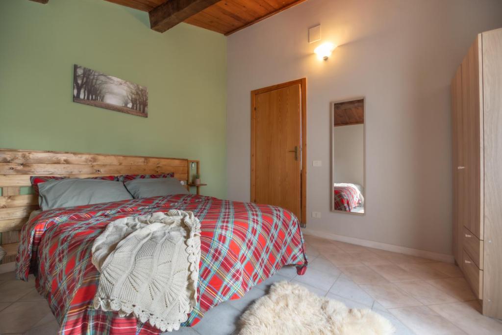 een slaapkamer met een bed met een houten hoofdeinde bij Rustic Italian House in Roccamorice