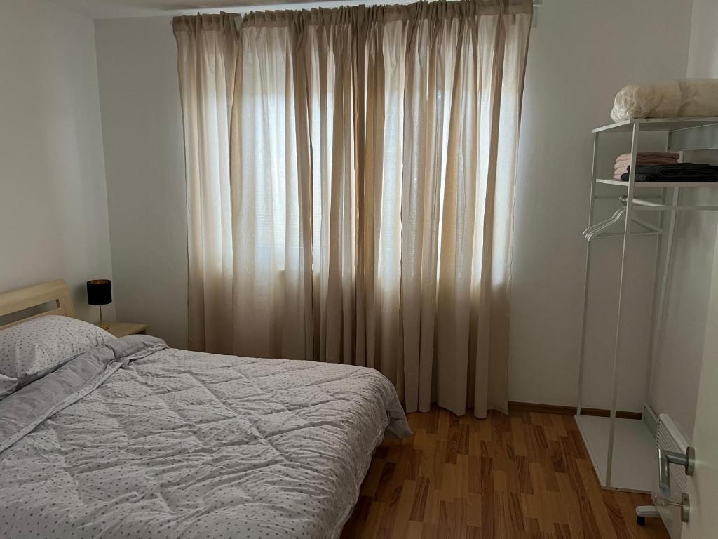 een slaapkamer met een bed en een raam met gordijnen bij Apartman Ivano Kupres in Kupres