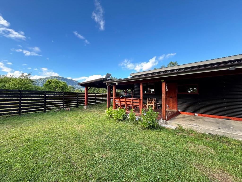 a house with a fence next to a yard at Cabaña en Panguipulli, lugar tranquilo in Panguipulli
