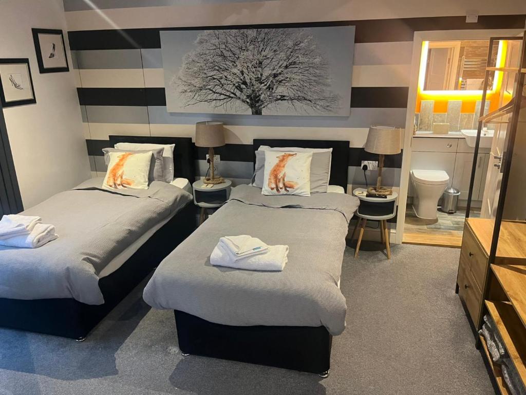 een kamer met 2 bedden en een badkamer bij CopperBeech Bed and Breakfast in Yoxford