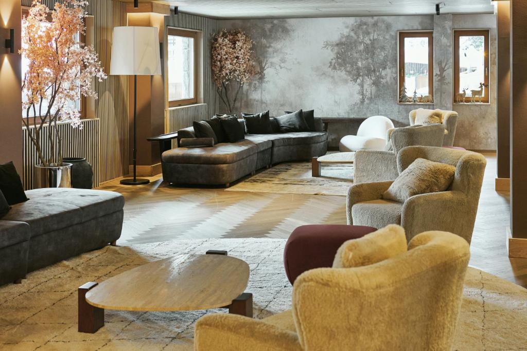 a living room with couches and chairs and a table at Hotel Europa in Breuil-Cervinia