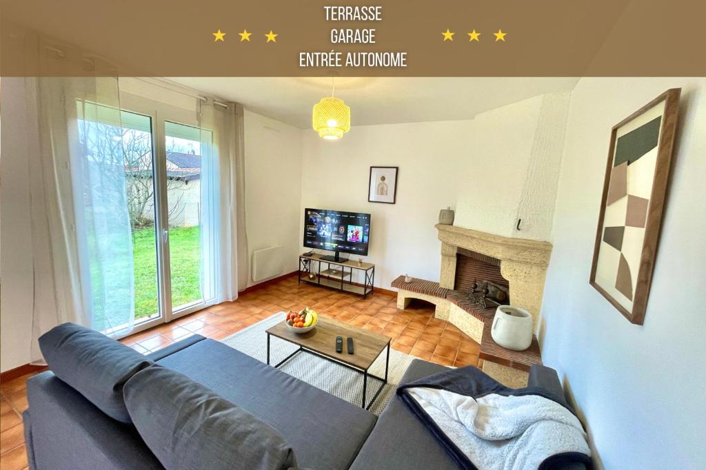 een woonkamer met een bank en een open haard bij " Au coin du Lys " Garage - Jardin - Wifi in Saint-Lys