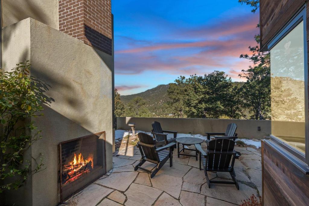 a patio with a table and chairs and a fireplace at Casa de Flechas in Santa Fe NM in Santa Fe