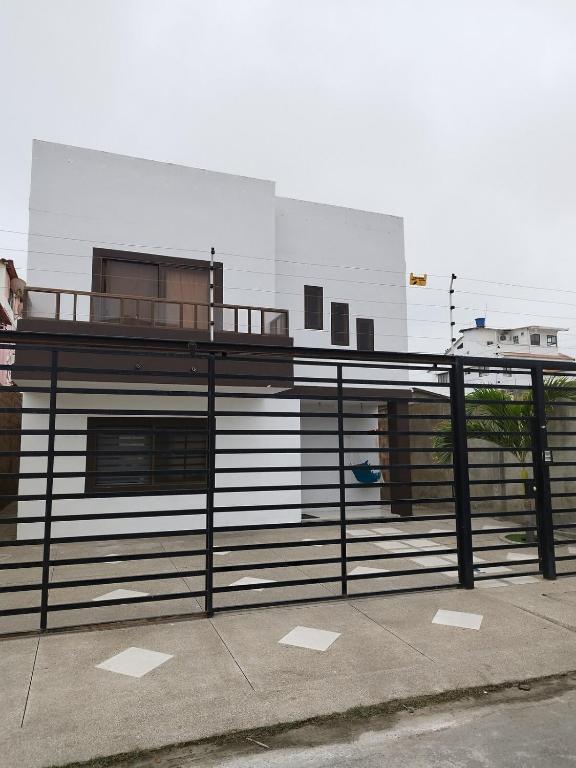 a building with a metal fence with a building at Casa Familiar a 5 minutos de la playa in Salinas