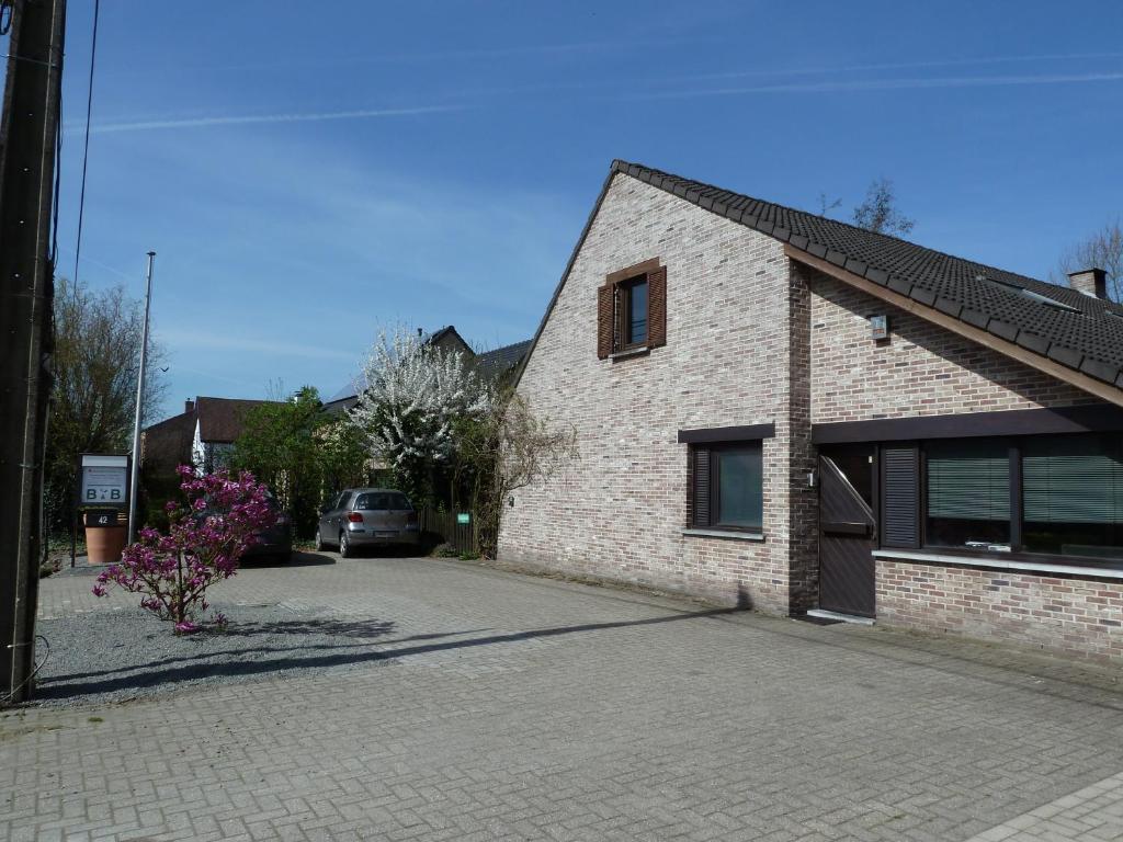 a brick house with a car parked in a driveway at BnB Heimdall in Brecht