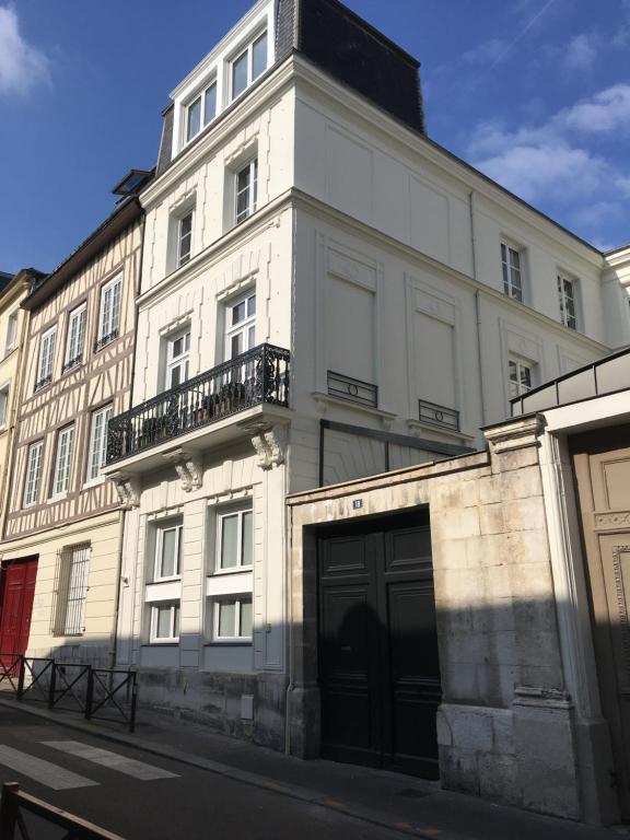 un grand bâtiment blanc avec un garage dans une rue dans l'établissement Le Dix-Huit Studio Duplex, à Rouen